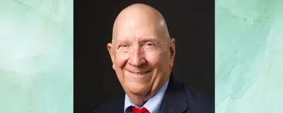 photograph of john pawalek in a navy blue suit and red tie